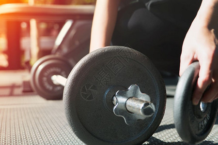 妇女用手在健身房的肌肉结构中安装钢铁哑铃锻炼男人训练图片