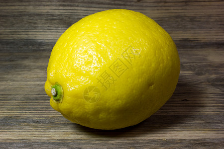 黄色的青木制背景上的一个黄色柠檬优质的图片