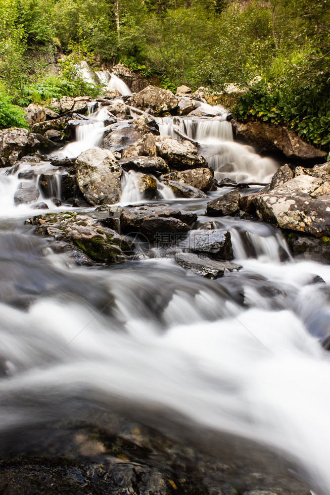 湿的夏天急流河水在岩石中的快速流动沿河出行流着图片