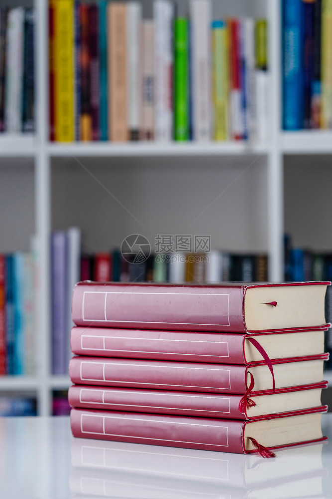 读红书堆在白桌上的子在天前视家庭背景的书架前头观智慧子图片