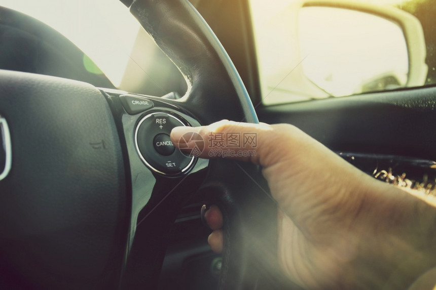 转变系统司机手按着汽车方向盘上适应巡航控制按钮的驾驶手车轮图片