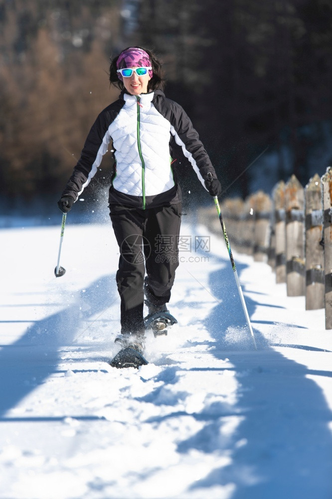 冒险一位年轻女子在游览中雪鞋季节旅行图片