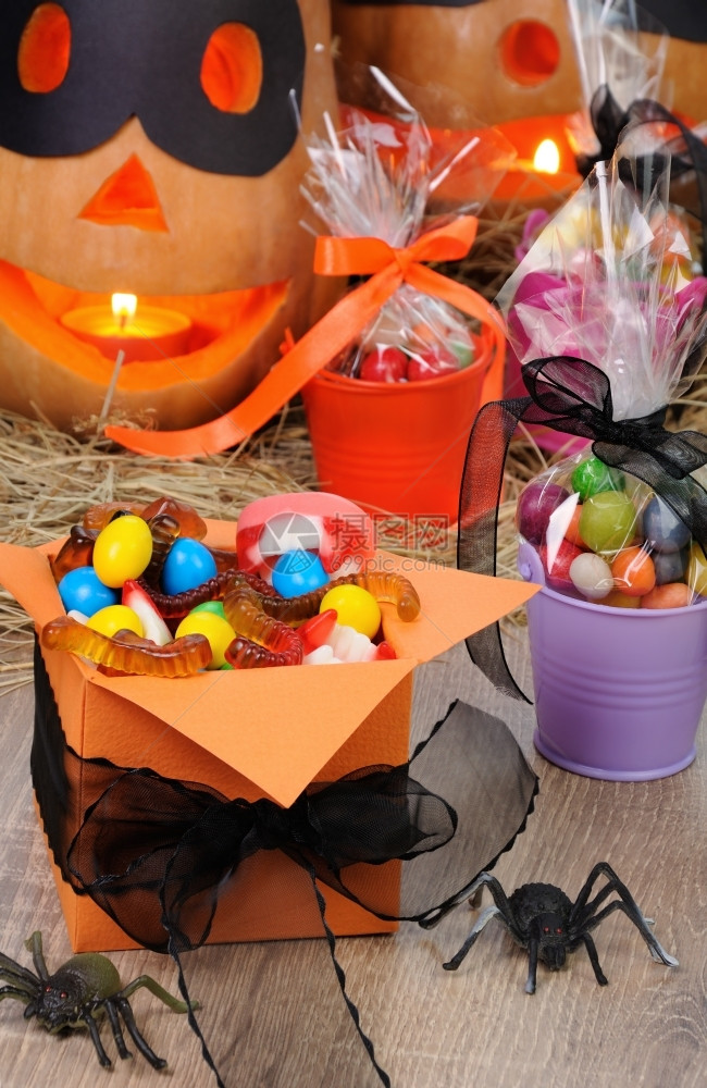 假期牙齿丝带在万圣节的桌上装满各种糖果的盒子里图片