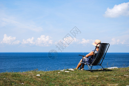 经过坐在椅子上风景美丽的瑞典波罗海女坐长椅上妇绿色海洋图片