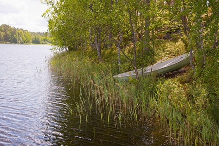 沉默的绿色游船在芬兰湖上搁浅均衡背景图片