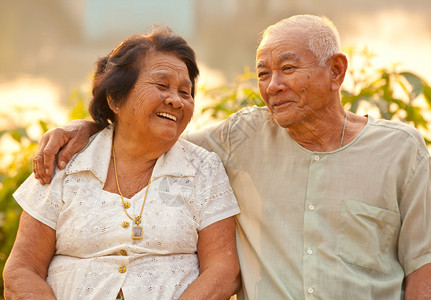 男人陈年坐着日落时在户外的亚洲幸福老年情侣图片