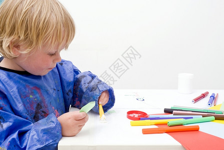 胶水单身的白种人年轻男孩在一张桌子上纸毡笔高清图片素材
