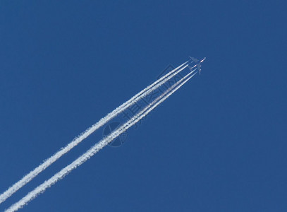 乘客运动或者蓝天上的飞机和对角凝聚轨迹或比物图片