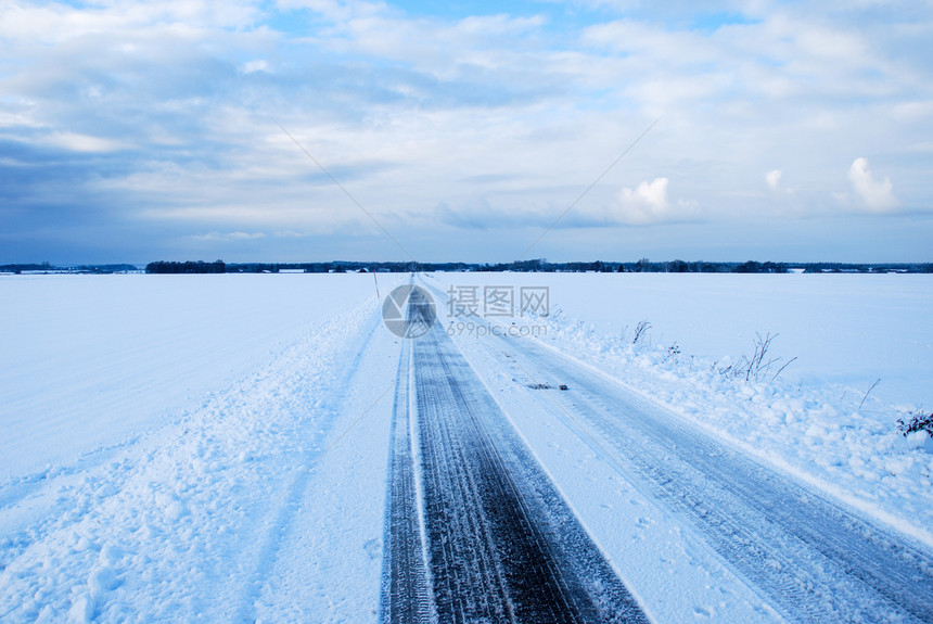 穿越平原地貌的直雪乡村道路的场景冬天图片