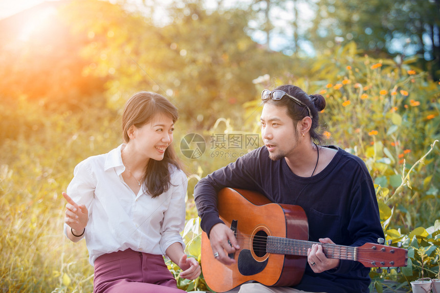花园户外情侣年轻的亚洲男女在公园里轻松地弹吉他图片