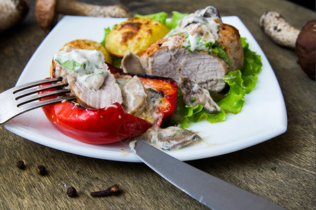 食物蔬菜猪肉牛排加烤土豆和白盘蘑菇酱烘烤的图片