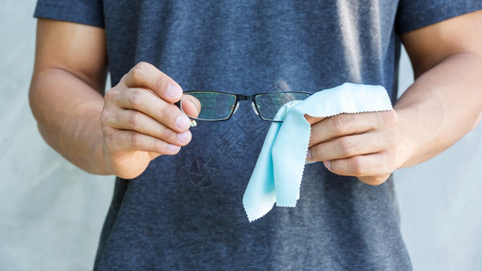 男人用微纤维织物清洗眼镜打扫毛巾餐纸图片