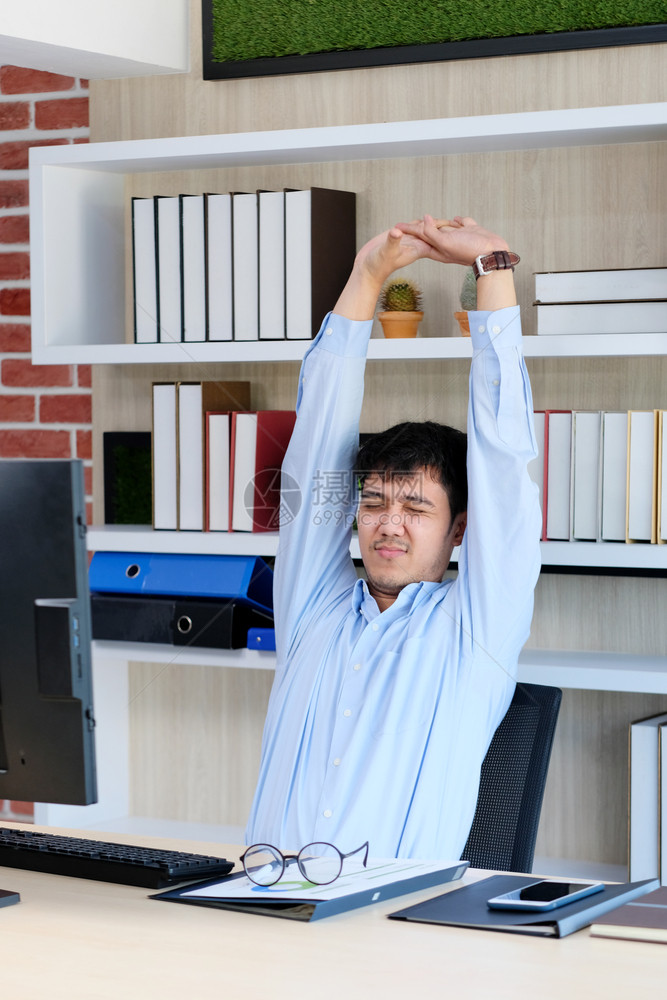 尽管年轻的青亚洲人办公室男子在桌电脑室生活方式商业状况等工作时伸展身体以放松力随意的技术图片