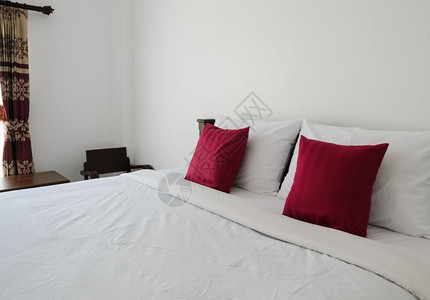 床单家具白色卧室有整洁的国王床和红色枕头的图片