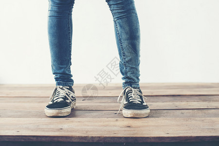 木制的青少年女士时髦酷人脚搭配黑色运动鞋柔软复古色调时髦酷女人脚搭配黑色运动鞋柔和复古色调背景图片