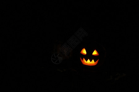 南瓜雕刻黑暗的可怕灯笼万圣节恐怖鬼脸上闪耀的亮面罩在黑暗中的万圣节设计图片