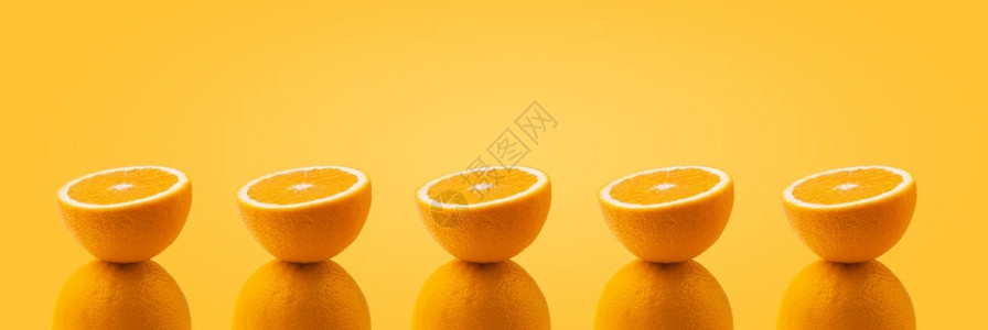 新鲜多汁的工作室半片橙色平衡在一整柳橙色上在多彩背景全图像上图片