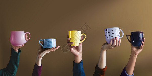 早晨提高以展示自己的杯和最喜爱饮料为主人们举起手来展示自己的杯子和最爱饮料会议背景图片