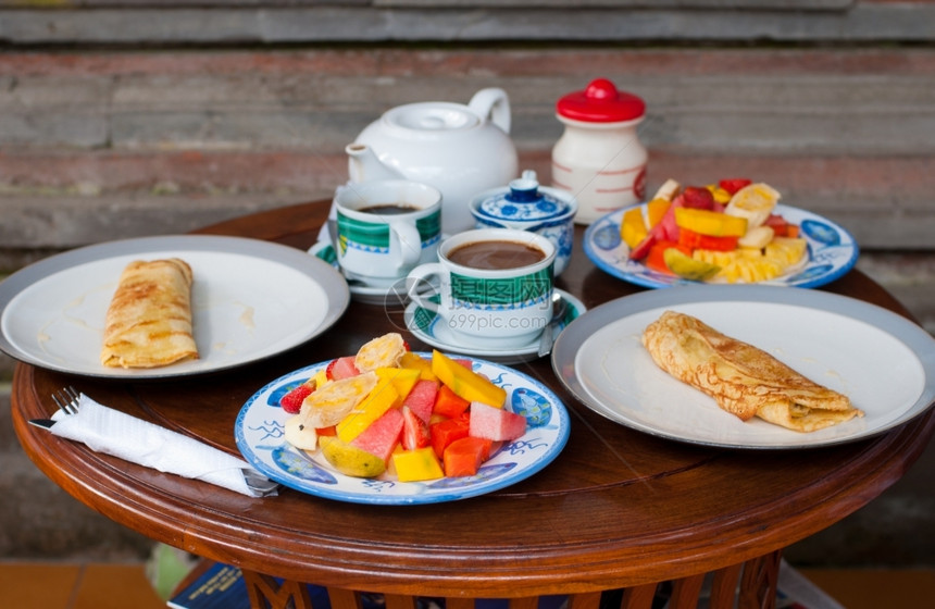 早期的白色餐与煎饼和新鲜水果在乌布德美食图片