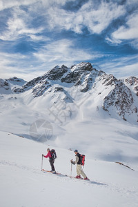 远足在瑞士阿尔卑斯山游滑雪旅行期间的退休运动员朋友人登山背景图片