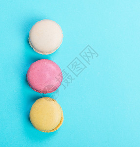 蓝色背景图视上的多彩和美味法国马卡龙咖啡店甜的杏仁饼图片