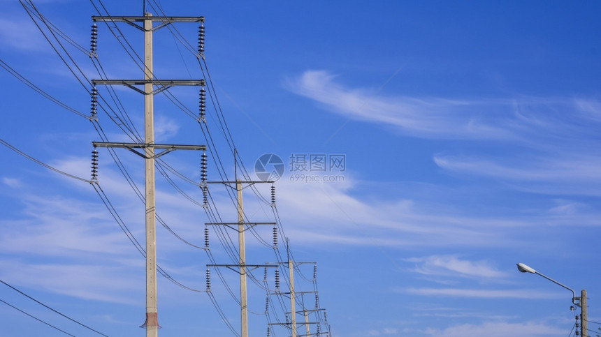 分配技术带电缆线与蓝色天空背景的白云对立电动线杆行用复制空间进行低角度视图线条图片