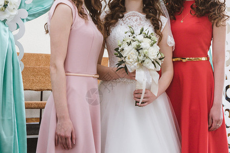 幸福白种人女孩紧贴新娘的束花和伴穿礼服图片