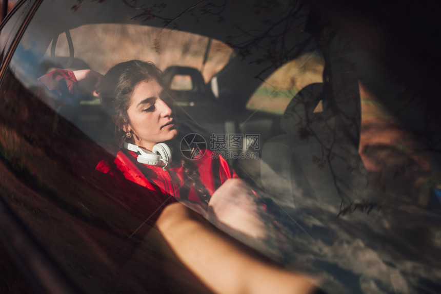 一种多云的年轻妇女在田地下雨时躲一辆汽车内避难年轻的图片
