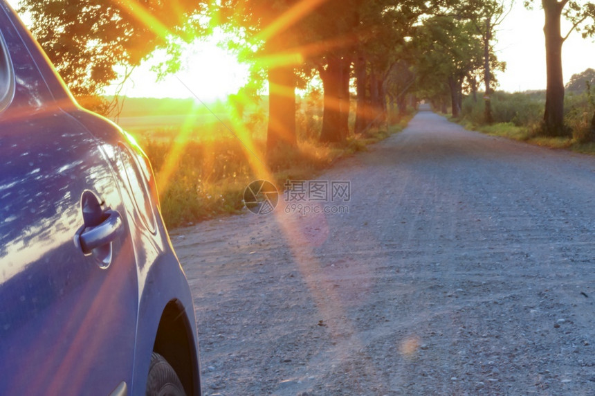 日落和汽车阳光下的蓝色汽车在路上阳光下的蓝色汽车在路上日落和汽车天交通驾驶图片
