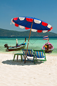 假期海洋泰国珊瑚岛Komodo海滩的雨伞和座椅子图片