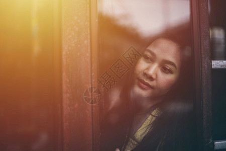 玻璃孤独思维站在窗户旁看的亚洲女人图片