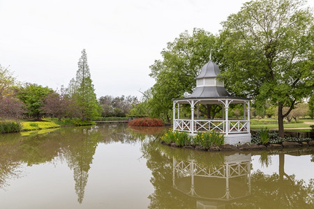 宝塔干净的夏天一座白色塔四周环绕着大花园池塘的树木和花朵背景图片