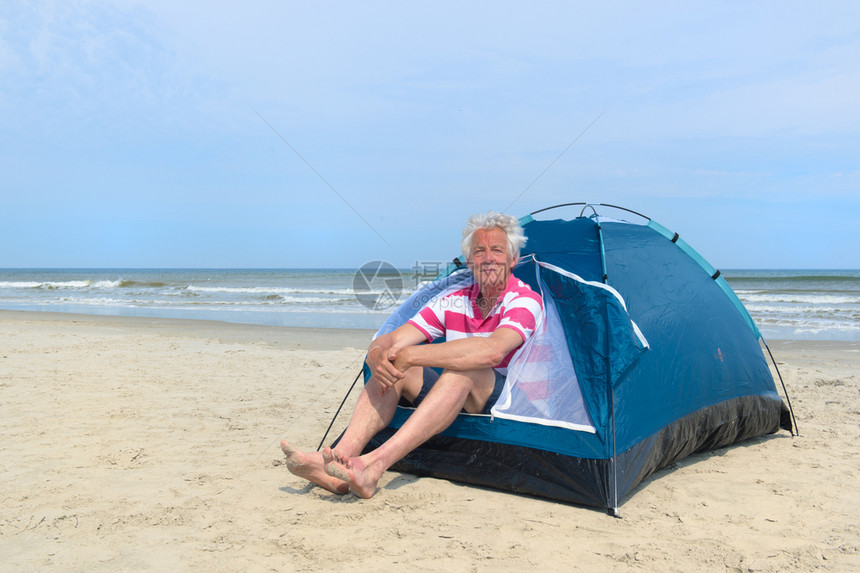 在海滩搭帐篷的爷爷图片