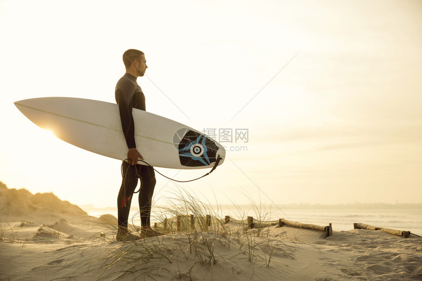 一个在沙丘上冲浪的者仰望着海水木板冲图片