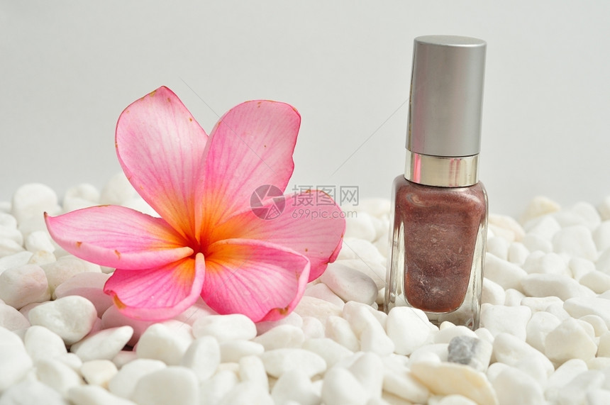 玻璃颜色用粉红弗朗吉帕尼花朵在白石子上展示的甲油盛开图片