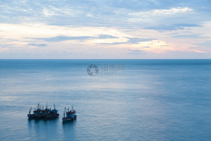 海岸早晨日出中渔船在清晨平静的海浪中天空开始于清晨图片