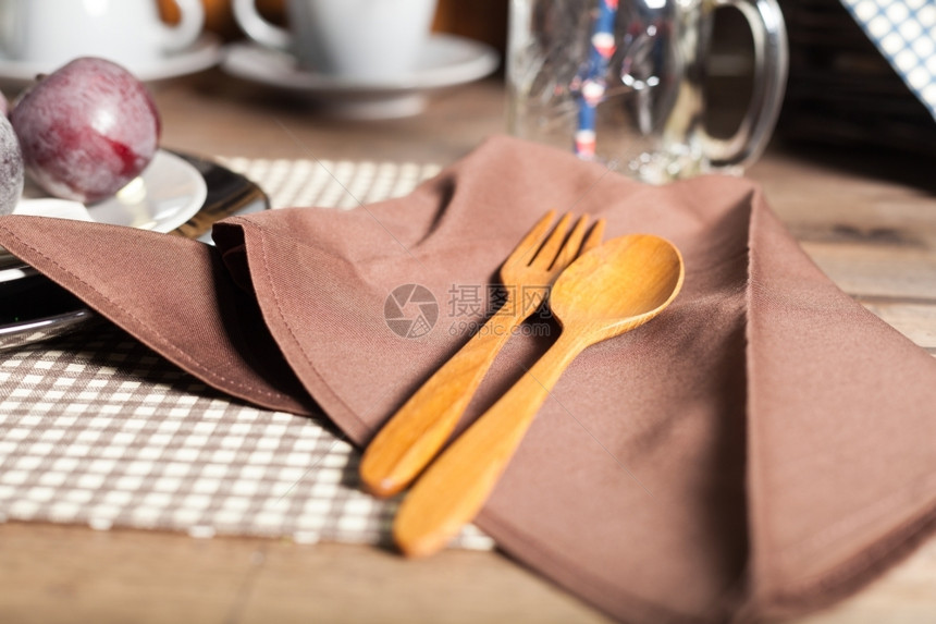 银木勺和叉子放在餐巾纸上用具图片