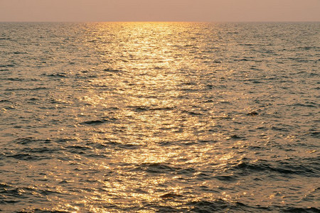 晚上海中日落的太阳光照耀着夜晚的海面黄色美丽图片