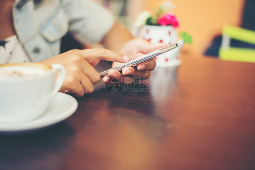 聪明的电话沟通女人在咖啡店用手机发短信的特写镜头女人在咖啡店用手机发短信的特写图片