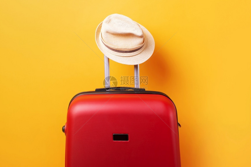 带帽子超过黄色背景的手提箱最低创造旅行概念最小目的飞机场包图片