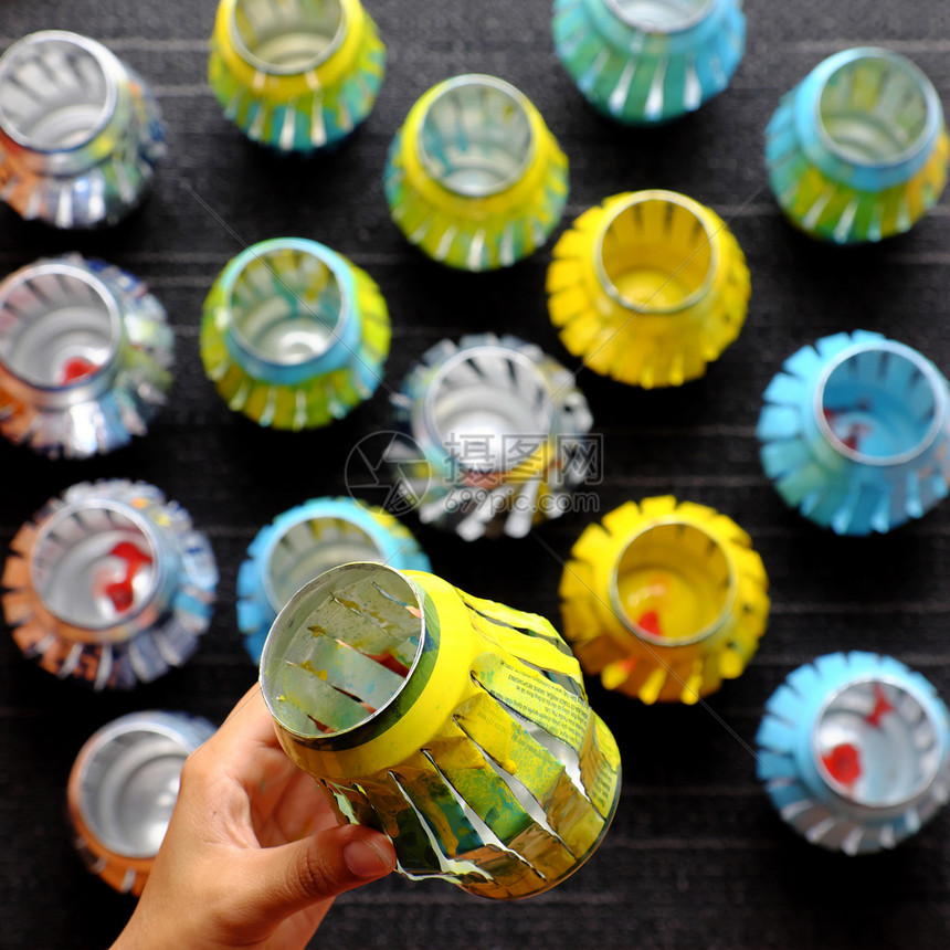 为了妇女手工回收啤酒罐用切割和喷漆来回收啤酒罐在秋节中做灯笼亚洲人手工制作的图片
