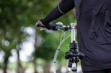 山循环在亚洲女自行车手的背后戴着套的放在自行车把上优质图片