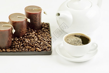 陶瓷咖啡杯加豆和蜡烛满的黑色图片