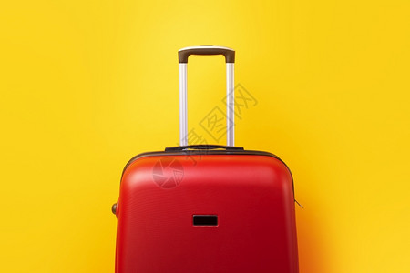 行李箱海报航程红色的旅行李箱在黄色背景上关闭的背景