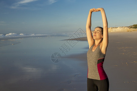 在海滩上做伸展运动的女性图片