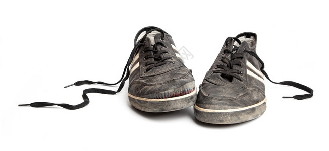 在白色背景上被孤立的肮脏旧黑色运动鞋靴子开机脚丫背景图片