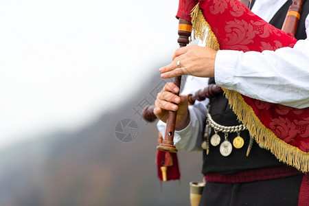 苏格兰服装在山上一个空旷的隙里玩Conramusa游戏播放器文化制服背景