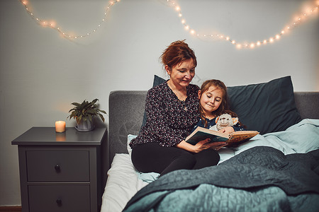 睡觉家为人父母妈睡前在床上给女儿看书睡前读故事给孩子听睡前故事图片