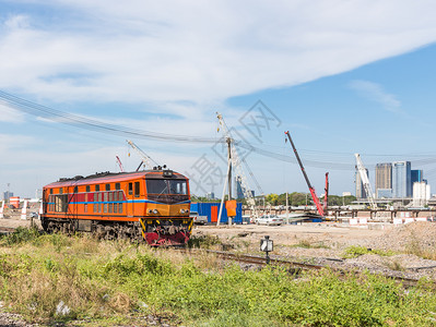 旅行追踪老的旧柴油电动机车经过城市站附近的建筑工地在城市车站附近图片