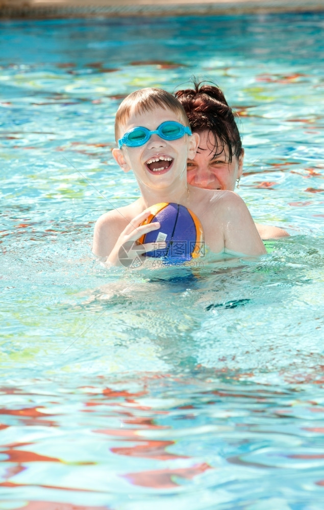 母快乐的亲和儿子在游泳池里玩白种人活动图片